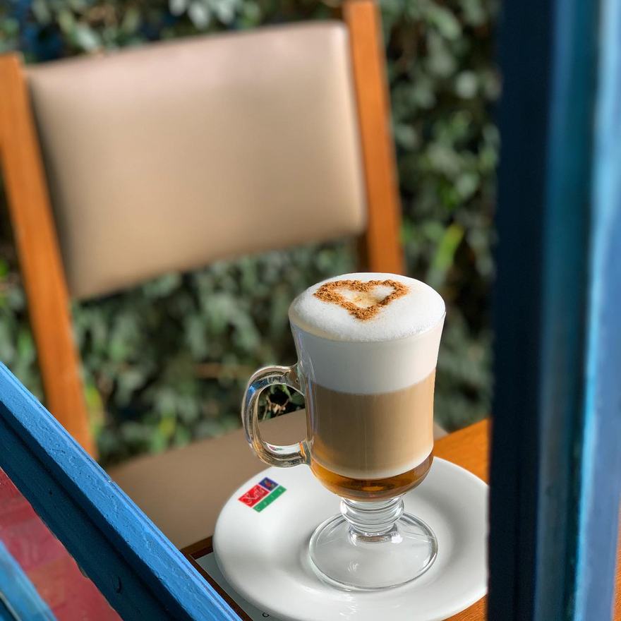 Café con leche servido junto a la ventana