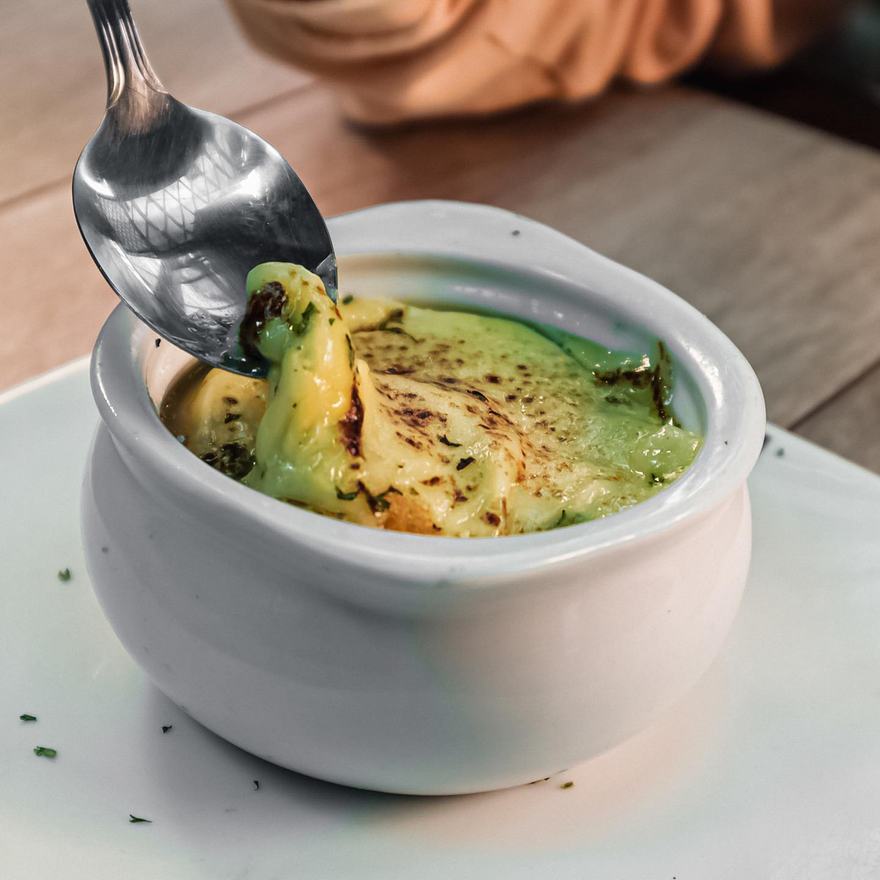 Crema de cebolla gratinada servida en pote de barro