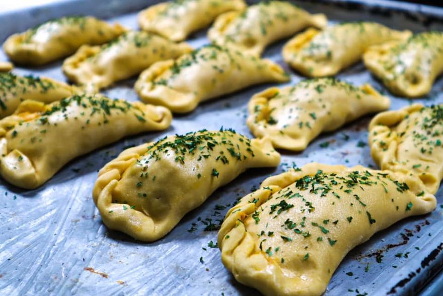 Empanaditas armadas a mano en la bandeja, antes de hornear