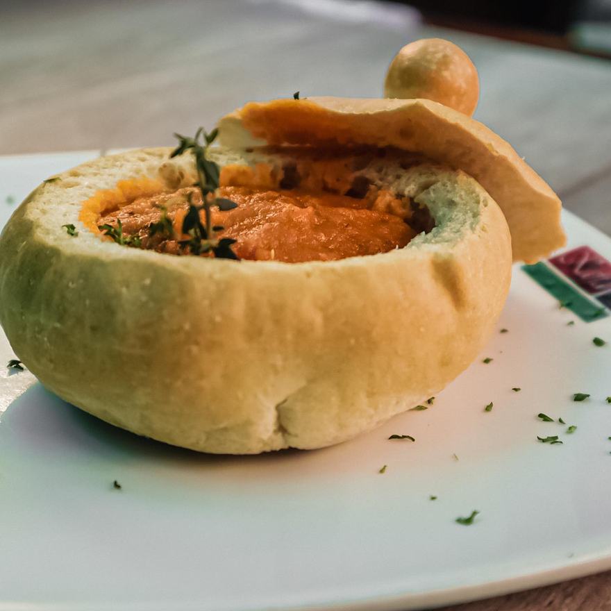 Fondue de quesos servido dentro de una hogaza de pan de la casa
